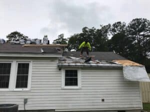 a man working on a roof of a house.