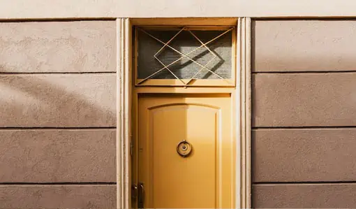 a yellow door with a window on a building.