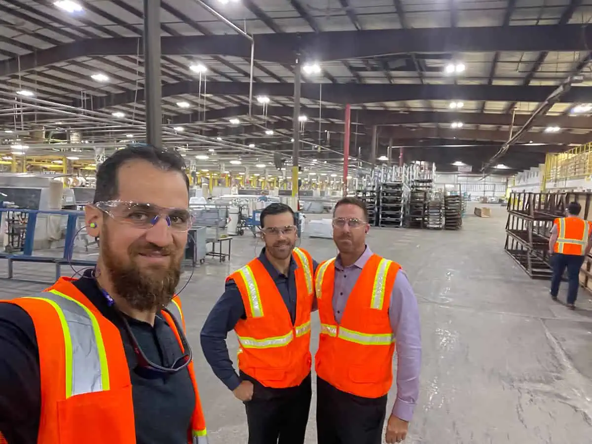 A group of career-minded men standing next to each other in a warehouse.