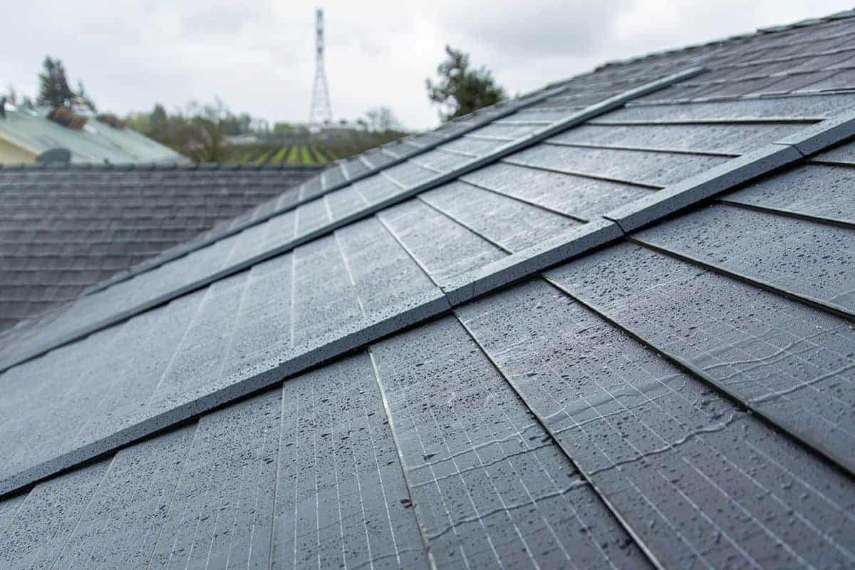 A close up of a roof with raindrops on Solar Shingles.