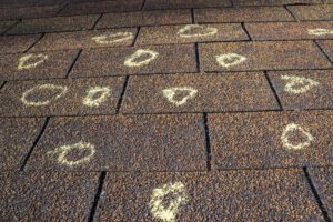 chalk marking hail damage on a roof